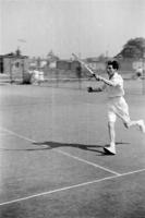 Woman playing tennis in white kit