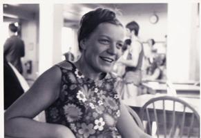 A woman in a flowery dress smiling