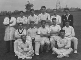 A group of men dressed in cricket whites.