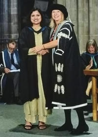 Amruta Ajit Mathpati shaking hands with an academic whilst graduating