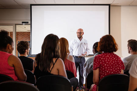 A group of students are listening intently in a lecture