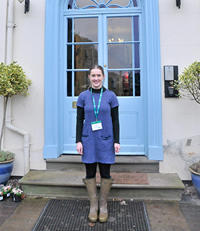 student in front of a blue door