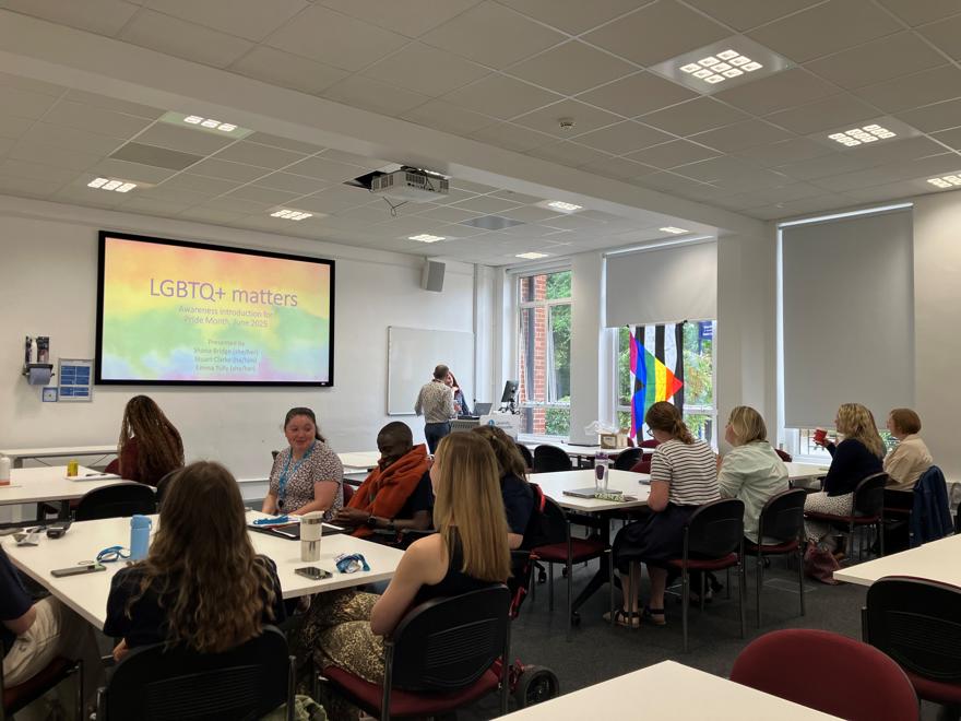 Staff sat in a seminar room listing to an LGBTQ+ awareness training session