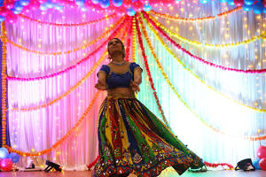 A brightly dressed lady is dancing at Onam
