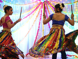 Two girls are brightly dressed and dancing at the diwali celebrations