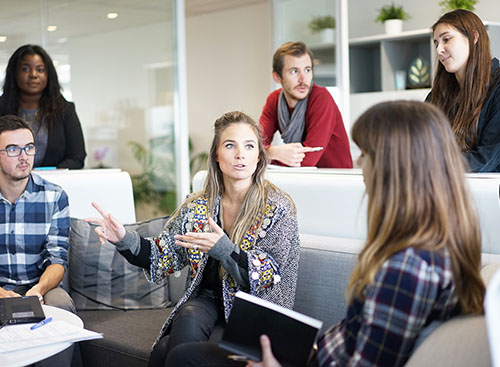 A group of young people are sitting in an informal business meeting