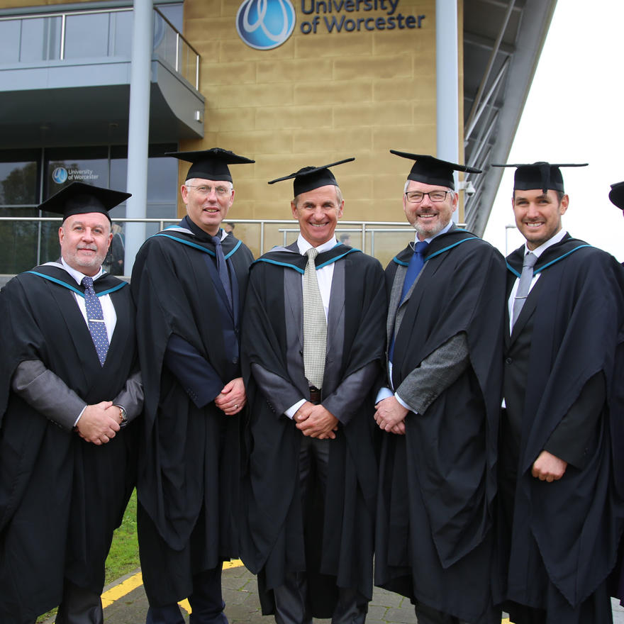 A group of men wearing graduation robes and mortarboards
