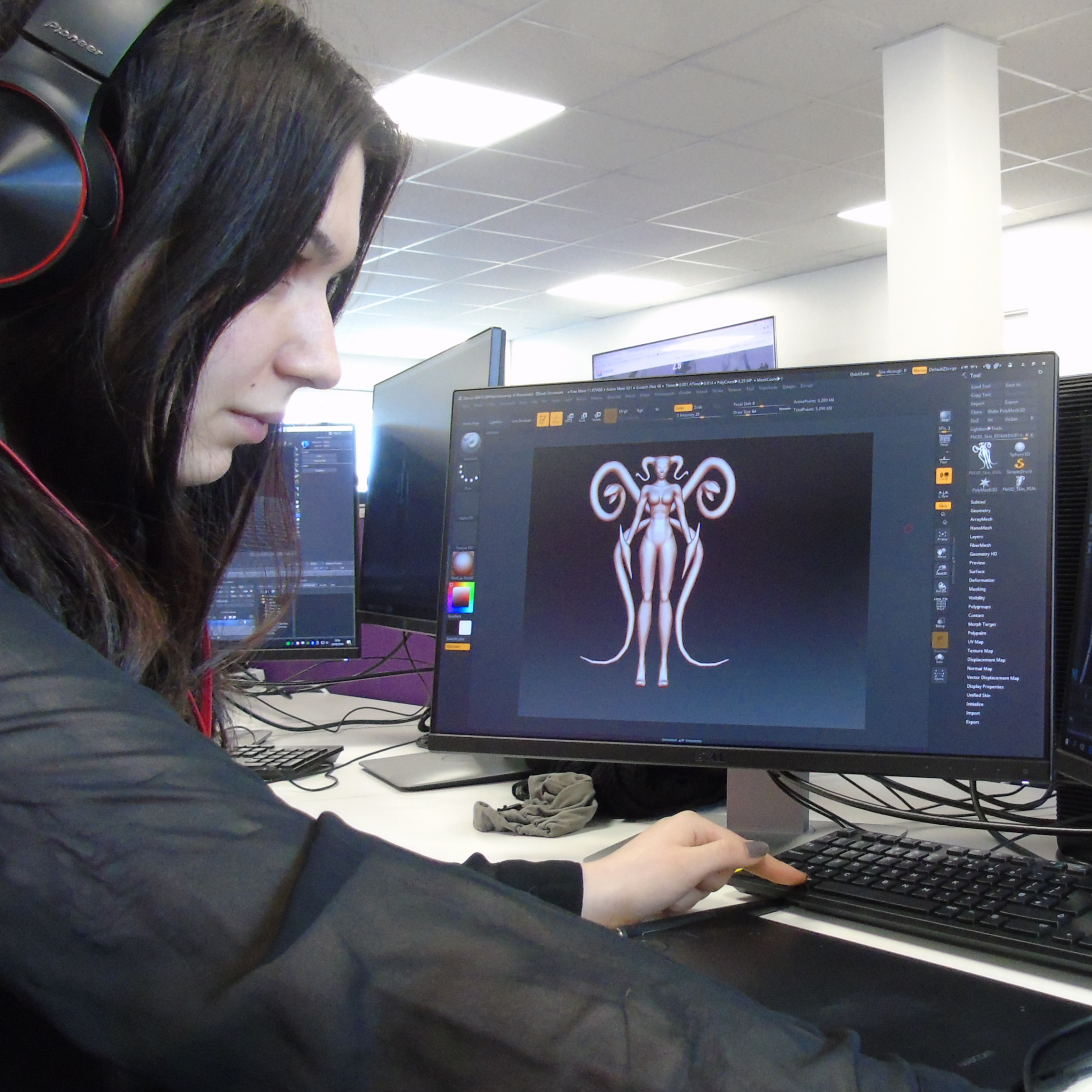 Student working on computer with artwork visible on screen