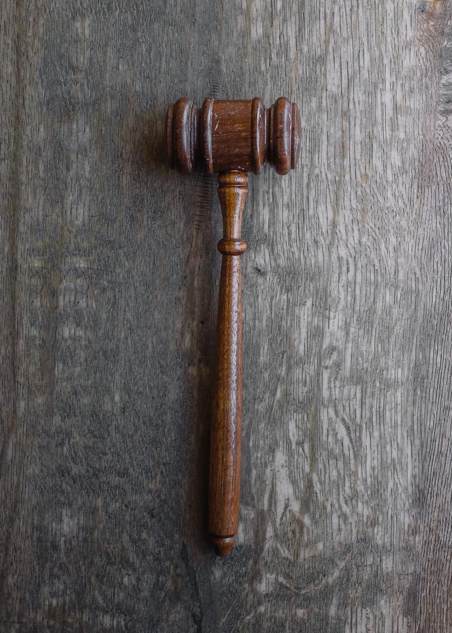 A wooden gavel with a grey background