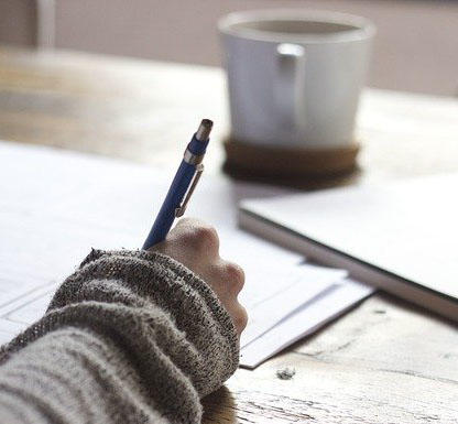 A person is handwriting on a table