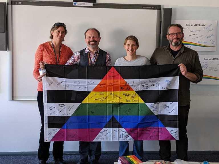 Several Staff members holding up the Allies Group flag