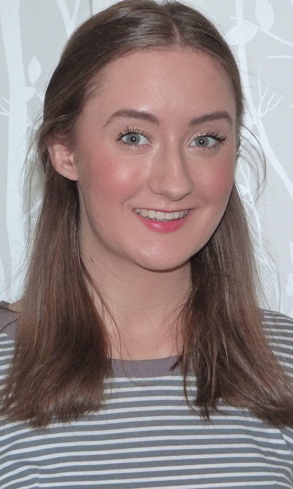 A woman in a striped shirt smiles at the camera