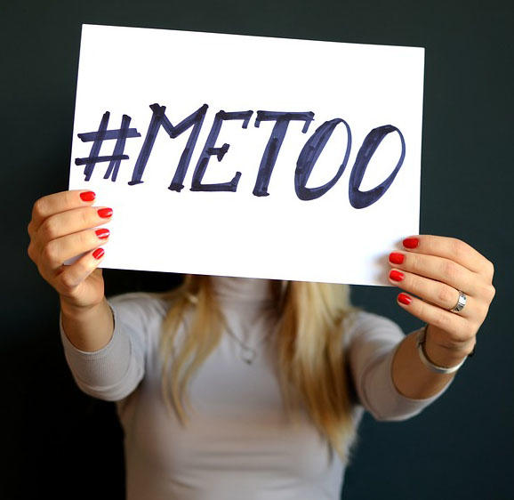 A woman is holding up a sign that says #metoo