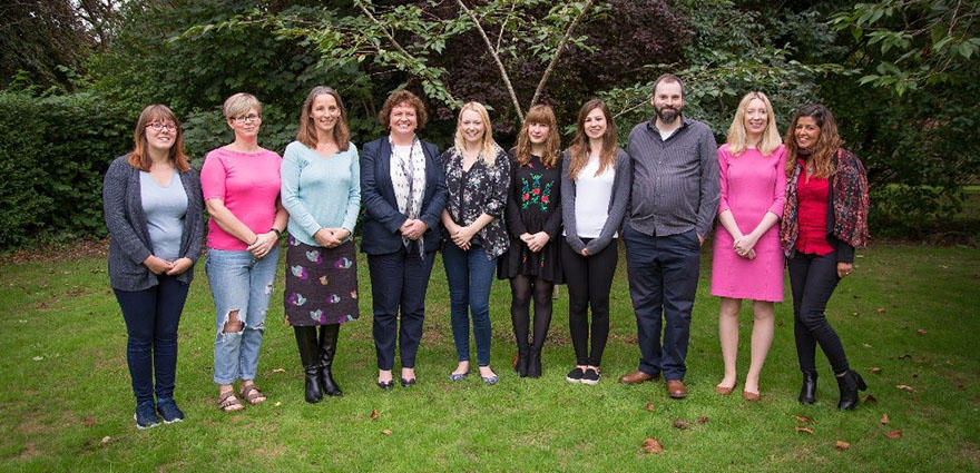 The Mood Disorders Research Group standing outside at the University. All of the group members are smiling