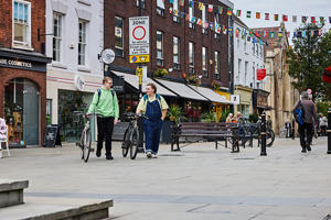 Two male students walking with bikes in Worcester
