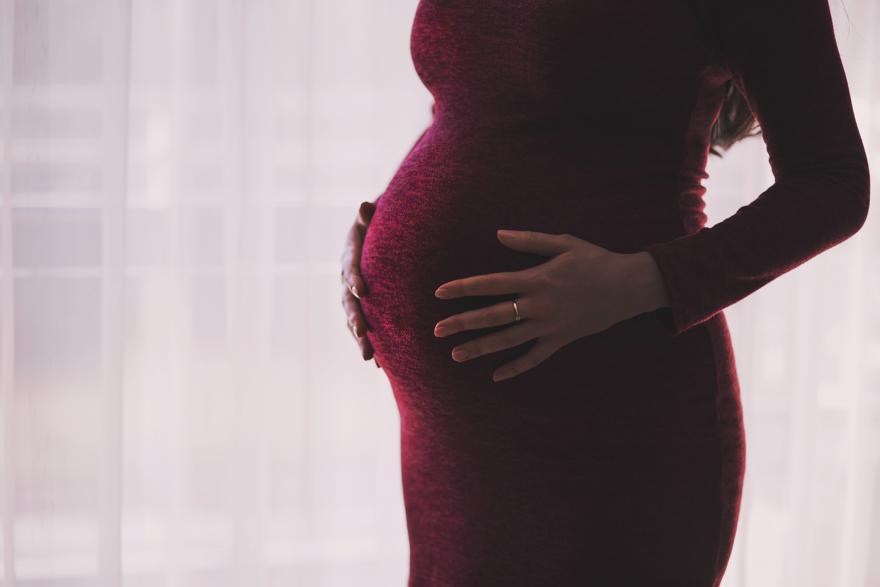 A pregnant woman holding her stomach