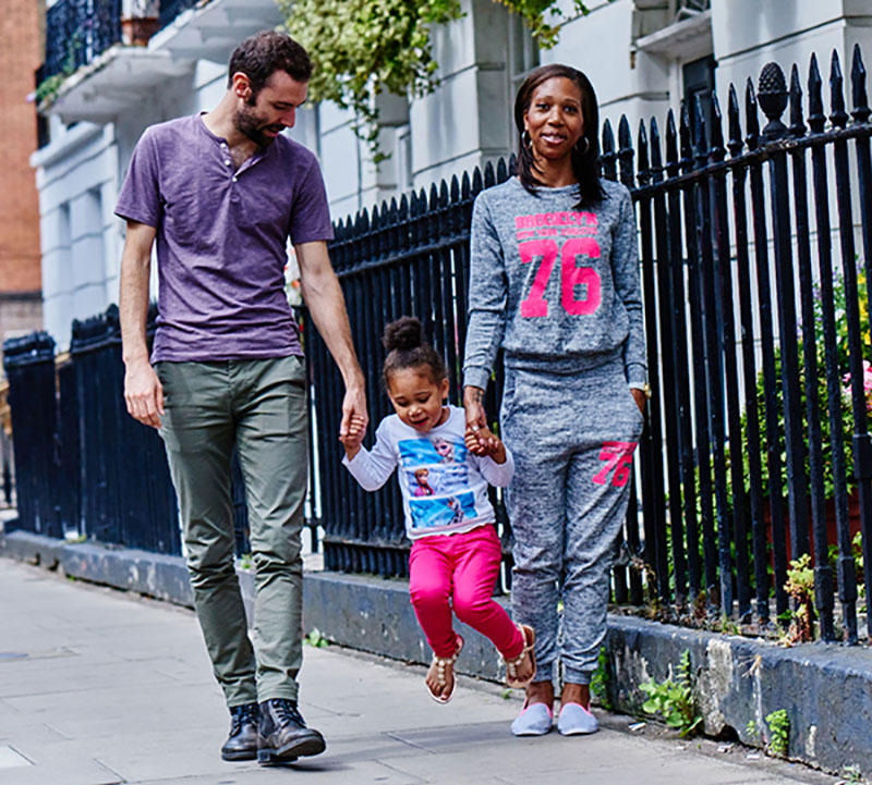 A family are walking down the street with their child