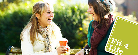 Students laugh outdoors while drinking coffee