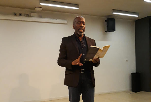Poet Roy McFarlane stood reading out poem