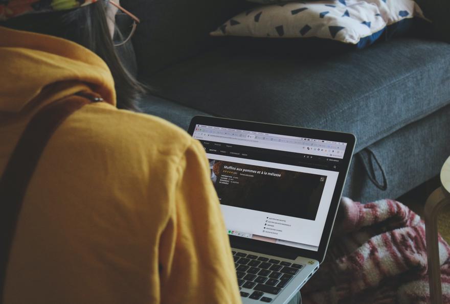 A woman in a yellow jacket looking at a computer screen