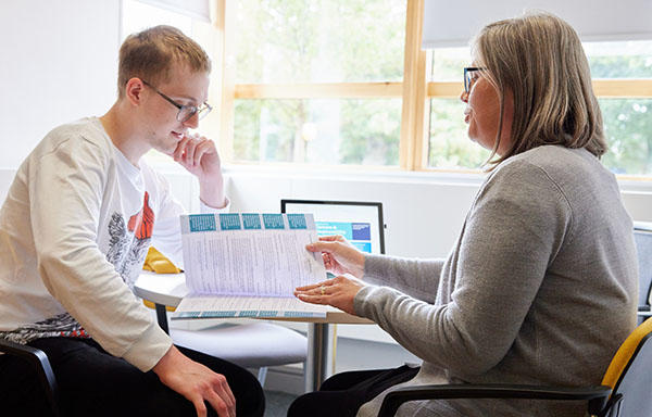 A member of the Firstpoint Team is helping a student