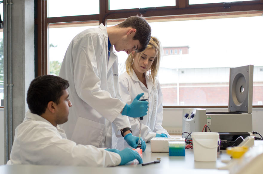 Science students in white coats in a lab