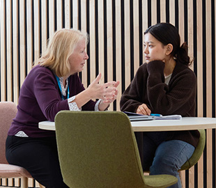 A lecturer speaking one-on-one to a student