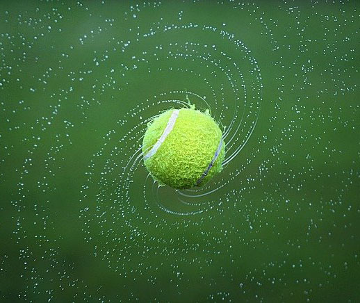 A close up shot of a tennis ball spinning