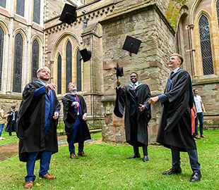 Four men throwing the caps outside of the cathedral
