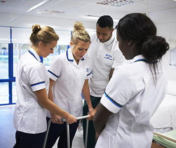 Several Occupational Therapy students are assisting another student with a zimmer frame