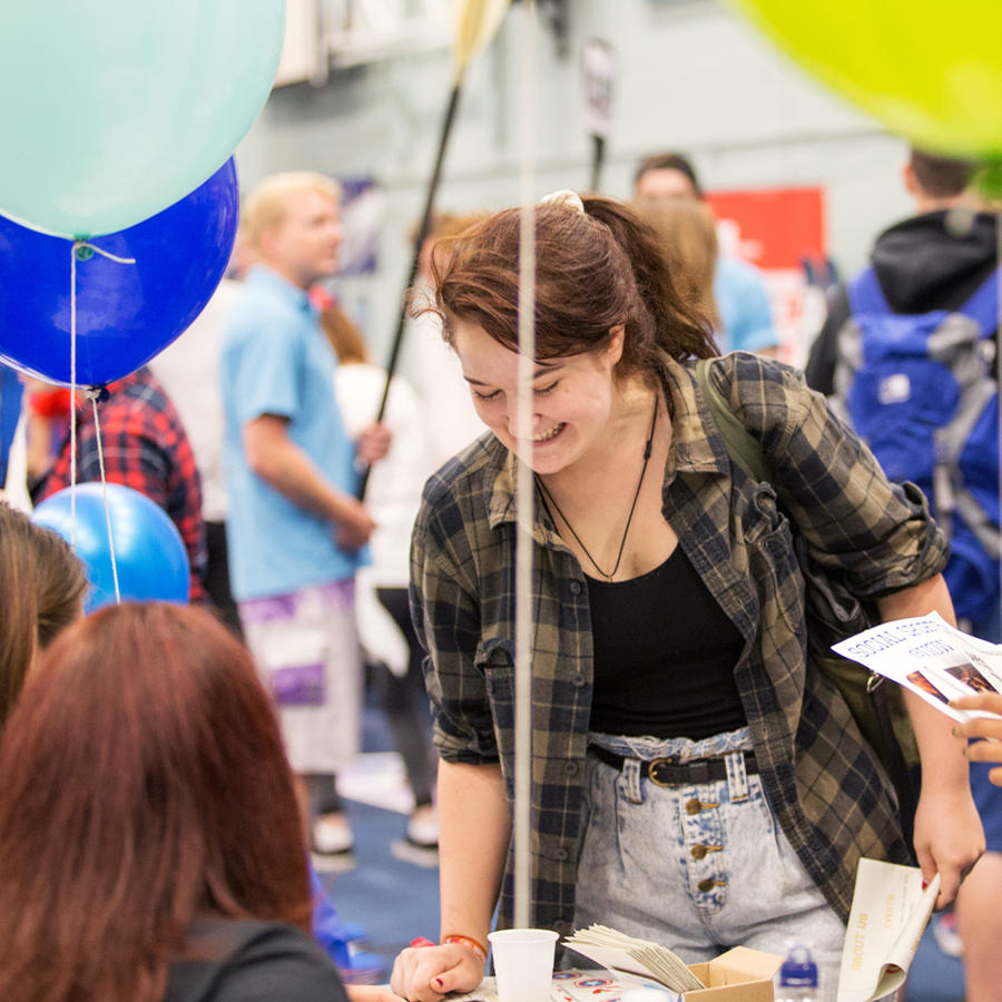 A new student signing up for a society at the welcome fair