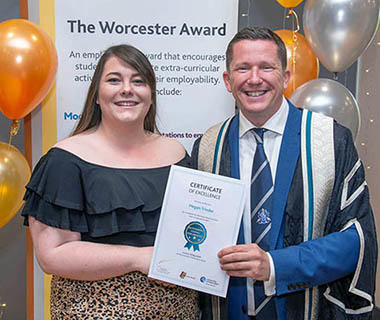 A student is receiving her Worcester Award Certificate from Ross Renton
