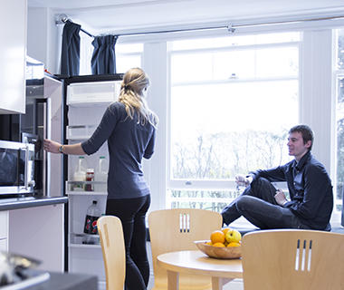 A male and female student in a kitchen in University halls of residence