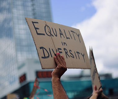 a sign being held in the air that says Equality in Diversity