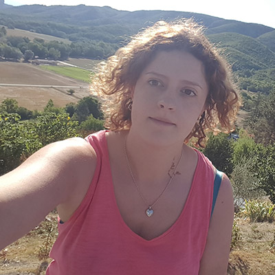 Woman in a pink top with hills in the background