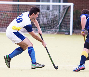 Man in a white top playing hockey