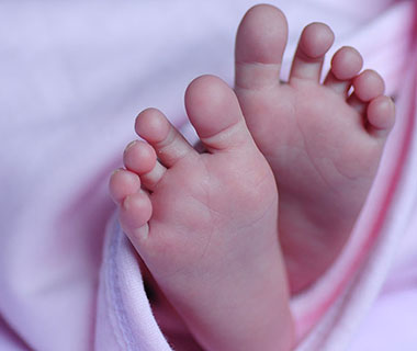 Baby feet poking out of a blanket