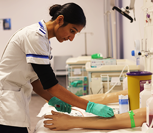 Nursing student working with a model arm