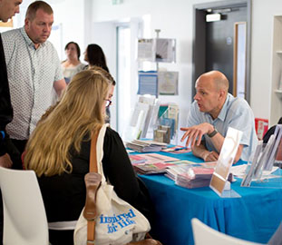 Applicants at a table listening to a lecturer