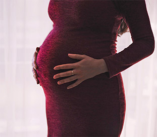 A pregnant woman holding her stomach