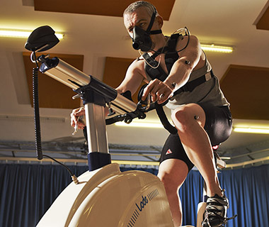 A man riding an exercise bike with oxygen monitoring equipment