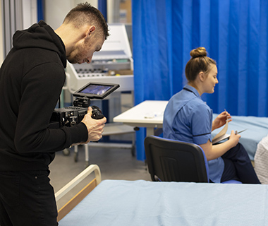 Camera operator filming a Nursing graduate