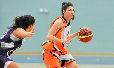 two young woman playing basketball